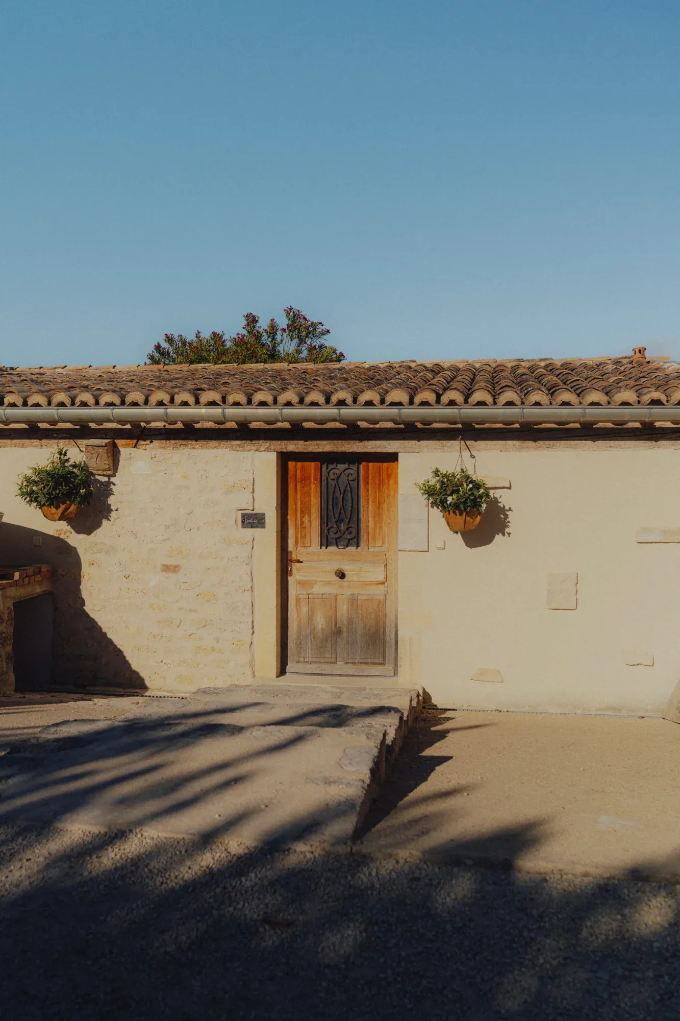 Façade d'un mas en pierre du domaine avec sa porte en bois
